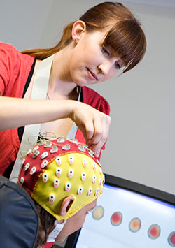 researcher placing EEG cap on patient