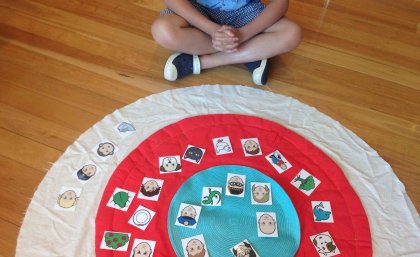 child sat on mat placing items in cirlce