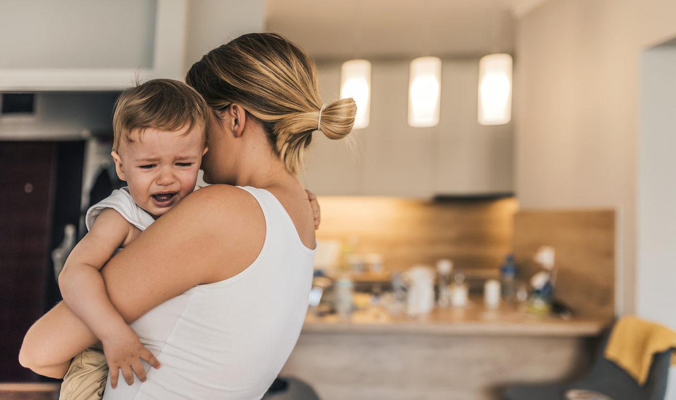 mother holding crying toddler