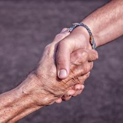 young hand shaking older hand