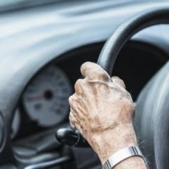 older hands on the steering wheel