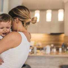 mother holding crying toddler