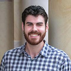 Mason Henderson standing in front of a sandstone brick building