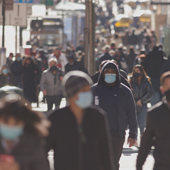 People walking on street wearing single use masks