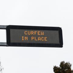 Road sign saying 'curfew in place'