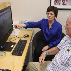 Dr Theresa Scott pointing to computer screen with dementia advocate John Quinn